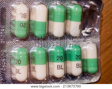 Close Up Detail Of Foil Packet Of Green And White Prozac Painkiller Tablets On Table Surface