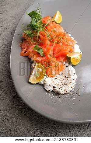 Lightly Salted Salmon With Cottage Cheese Cream And Limequat Is Served On A Gray Plate..