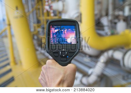 Production operator survey hot spot at hazardous area at offshore oil and gas remote platform to fine any abnormal condition of gas booster compressor by using thermo scan gun.