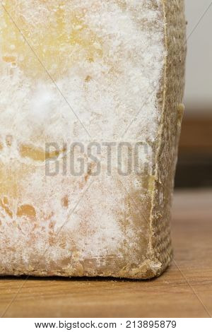 Moldy Cheese Close Up. Molded Clice Of Comte Cheese On The Cutting Board.