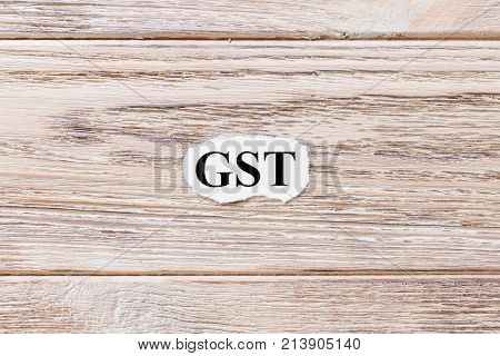 GST of the word on paper. concept. Words of GST on a wooden background.