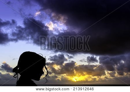 Silhouette of a young girl with sunrise over the ocean in background - Los Cocoteros, Lanzarote, Canary Islands, Spain