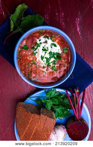 Ukrainian Traditional Borsch. Russian Vegetarian Red Soup  In Blue Bowl On Red Wooden Background.  B