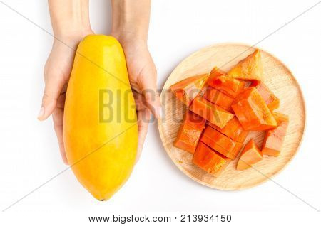 Top view of slice papaya fruit on wooden plate and papaya fruit holding by hand on white background