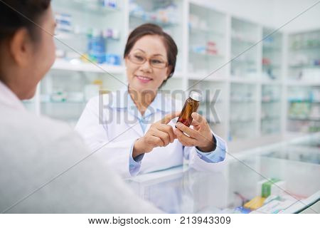 Pharmacist explaining contraindication of medicine to client