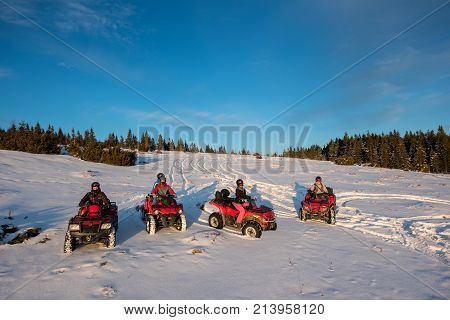Group Of People Sitting On Off-road Quad Bikes In The The Mountains In Winter Evening