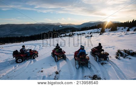 Group Of People Sitting On Off-road Quad Bikes, Enjoying Beautiful Sunset In The The Mountains In Wi