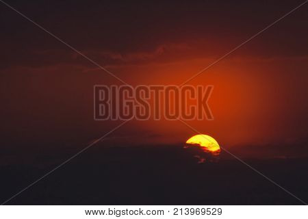 round yellow sun against a dark blue sky frosty fog in the evening