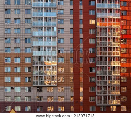 residential house red and brown lots of Windows the sun reflected in the Windows of the building