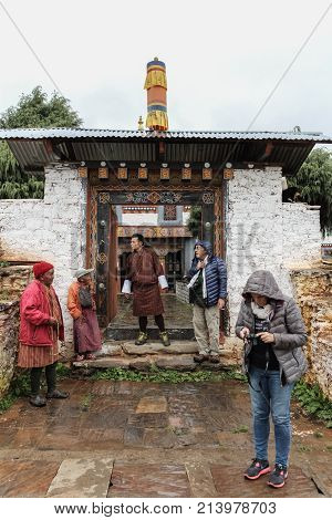 Trongsa, Bhutan - September 13, 2016: Tourist Group Waiting With Locals At Trongsa Dzong On A Rainy