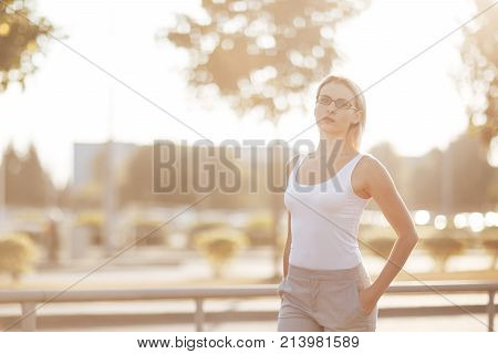 Portrait of a long hair blonde in glasses at sunset