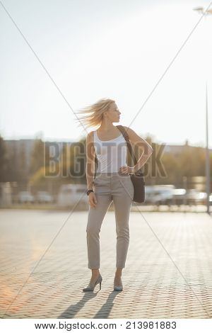 Business woman using a phone and clock while standing in outdoor