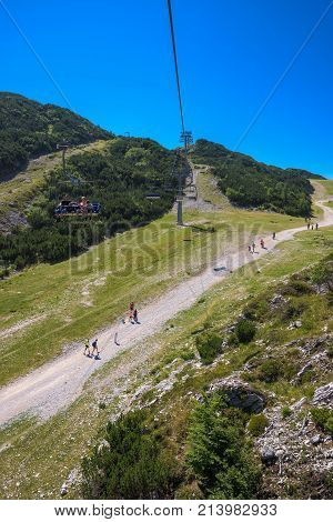 VOGEL MOUNTAIN SLOVENIA - AUGUST 30 2017: Aerial view of unidentifiable group of mountain hikers walking along footpath in popular travel destination for outdoor sports.