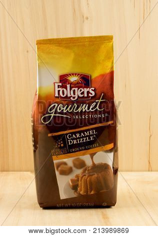 RIVER FALLS,WISCONSIN-NOVEMBER 15,2017: A bag of Folgers brand caramel drizzle ground coffee with a wood background.