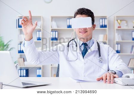 Young doctor with vr virtual reality headset working in the offi