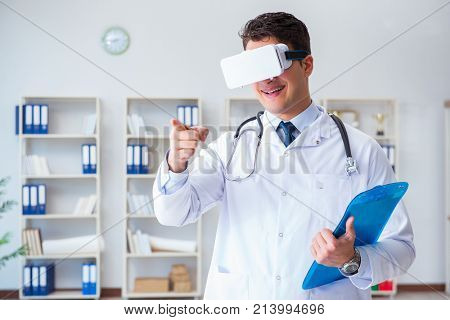 Young doctor with vr virtual reality headset working in the offi
