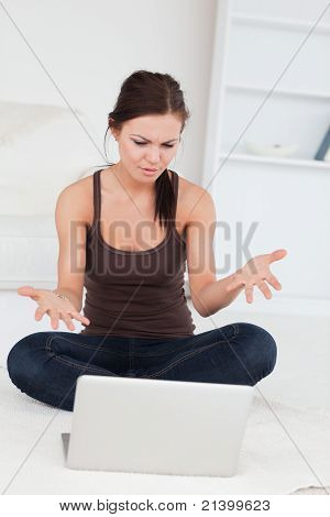 Vred mørkhårede kvinde ved hjælp af hendes Laptop