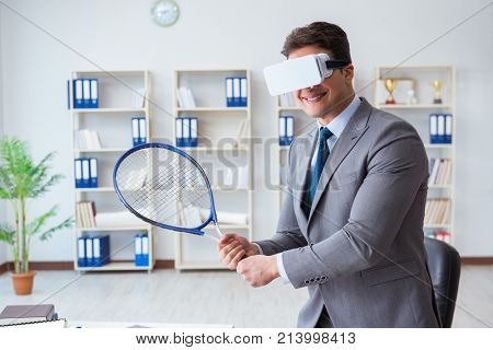 Businessman playing virtual reality tennis in office with VR gog
