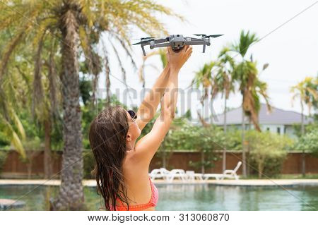 Female Launches A Drone For Flight, With Which You Can Take Photos And Videos, Near The Swimming Poo
