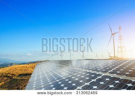 Solar Panels With Wind Turbines Against Mountanis Landscape Against Blue Sky With Clouds,alternative