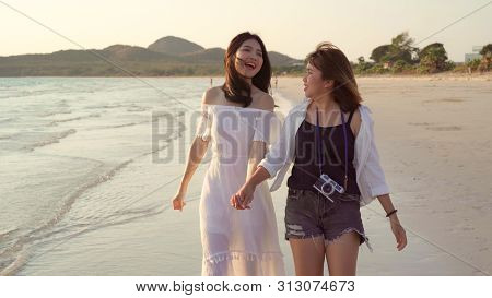 Young Asian Lesbian Couple Walking On Beach. Beautiful Women Friends Happy Relax Walking On Beach Ne