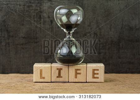 Living Time For Human Life Countdown, Lifetime Or Retirement Concept, Sandglass Or Hourglass On Wood