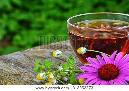 Cup Of Echinacea Tea On Old Wooden Table