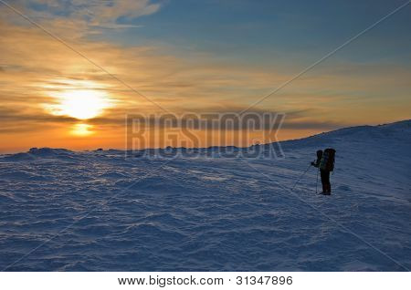 Trekker siluetti Sunset vuorilla