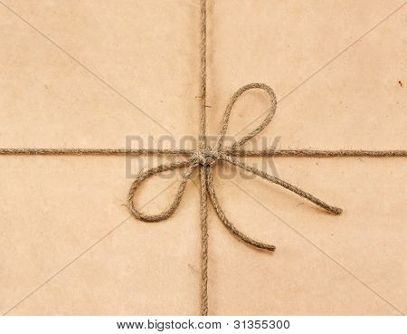 String Tied In A Bow On A Brown Recycled Paper
