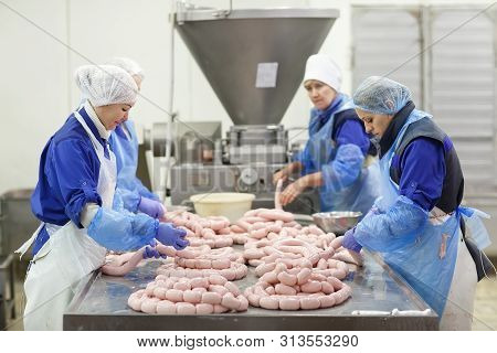 Cutting Meat In Slaughterhouse. The Meat And Sausage Factory.
