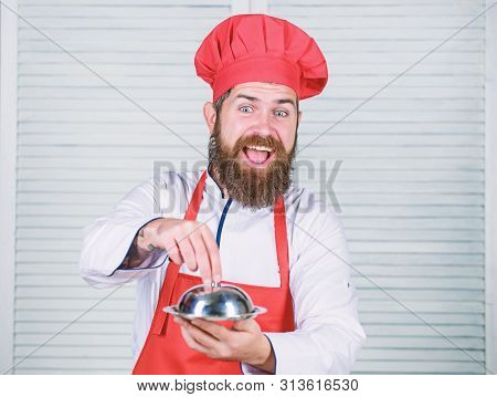 Man Hat And Apron Hold Meal Covered With Lid. Guess What I Cooked. What Is Under Lid. Delicious Meal