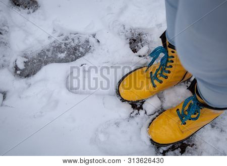 Unrecognised  Person Wearing Yellow Boots Standing On Fresh Snow After A Snowstorm
