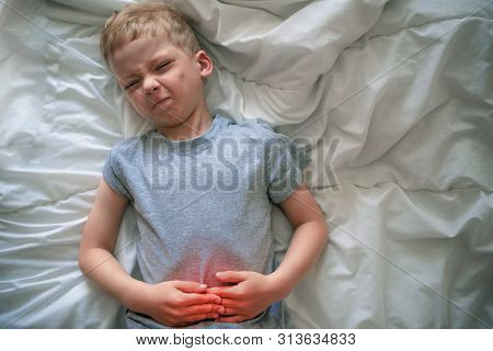 Abdominal Pain In A Preschool Child. Poisoning In Children. The Boy Holds His Hands To The Abdominal