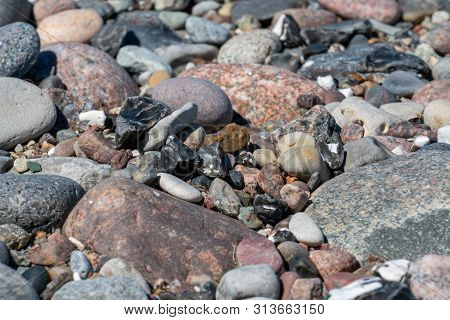 Multi Coloured Pebbles On A Beach In Bright Sunshine