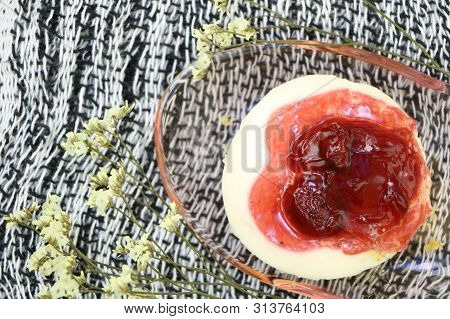 Close Up One Piece Of Strawberry Cheesecake With Red Strawberry Sauce , Top View On Fabric Backgroun