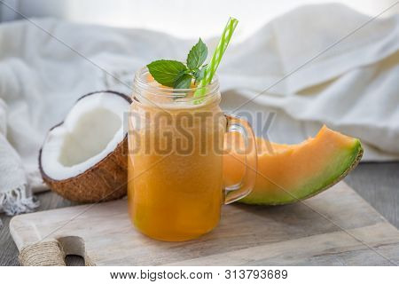 Photo Of Melon Smoothie In Jar With Straw On Light Background. Fresh Organic Smoothie. Health Or Det