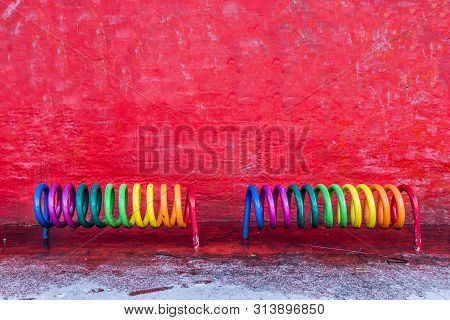 Copenhagen, Denmark - January 14, 2017: A Rainbow Colored Bicycle Rack In Front Of A Red Wall On The