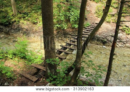 A Wooden Footbridge Running Along A Larger Stream In The Slovak Paradise National Park