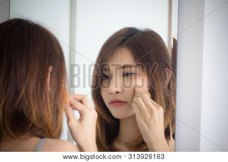 Portrait Beautiful Asian Girl Applying Powder Puff Foundationat Mirror In Bedroom.
Young Woman Makeu