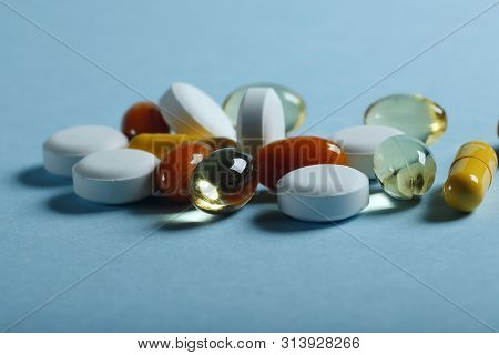 A Lot Of Bright Pills Of Drugs On A Blue Background. Cropped Shot, Horizontal, Side View. The Concep