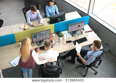 Top View Of Young Modern Colleagues In Smart Casual Wear Working Together While Spending Time In The