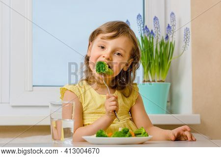 The Child Eats Broccoli With An Appetite. Organic Cabbage And Food On A Plate. Green Healthy Vegetab