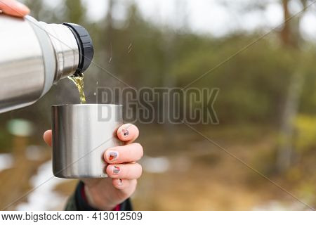 Youg Beautifull Women Pouring Beverage From Termos To Cup In A Cold Raini Day. Healthy Living And Hi