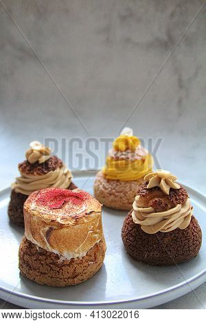 Four Different Sugar Puff With Cream, Chocolate Puff And Puff With Yellow Cream, Sweet Cookies Made 
