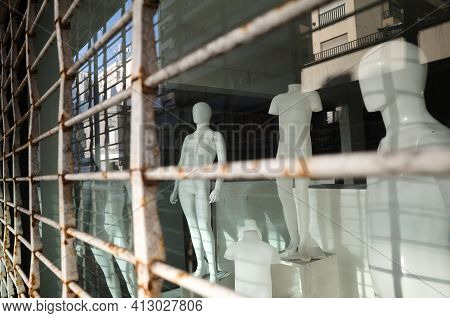Male Mannequins Without Clothes In A Shop Window. Naked Plastic Dummy In A Closed Store View Through