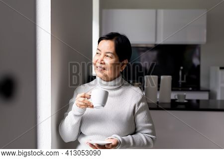 Elderly Asian Woman Drinking Coffee At Home,happy And Smiling,health Care Senior Insurance Concept