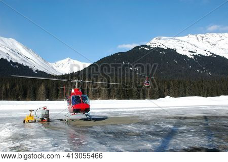 GIRDWOOD, ALASKA - 5 MAR 2007: Two Helicopters at Gridwood, Aaska Airport, one landed and one in flight