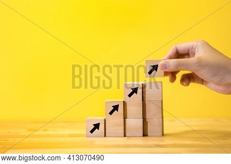 Business Growth Or Goal Concepts With Female Hand Puting Arrow Wood Box On Yellow Background