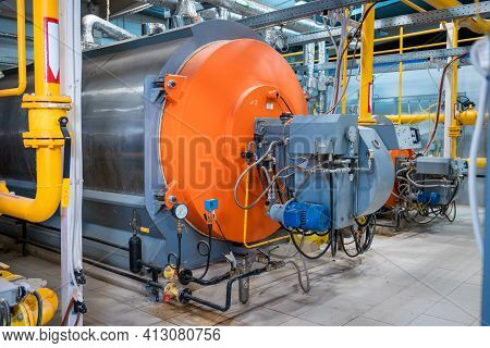 Industrial Heating Pipes And A Large Boiler. Red Vents On The Pipes. The Concept Of Industrializatio