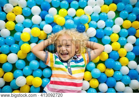 Child Playing In Ball Pit. Colorful Toys For Kids. Kindergarten Or Preschool Play Room. Toddler Kid 